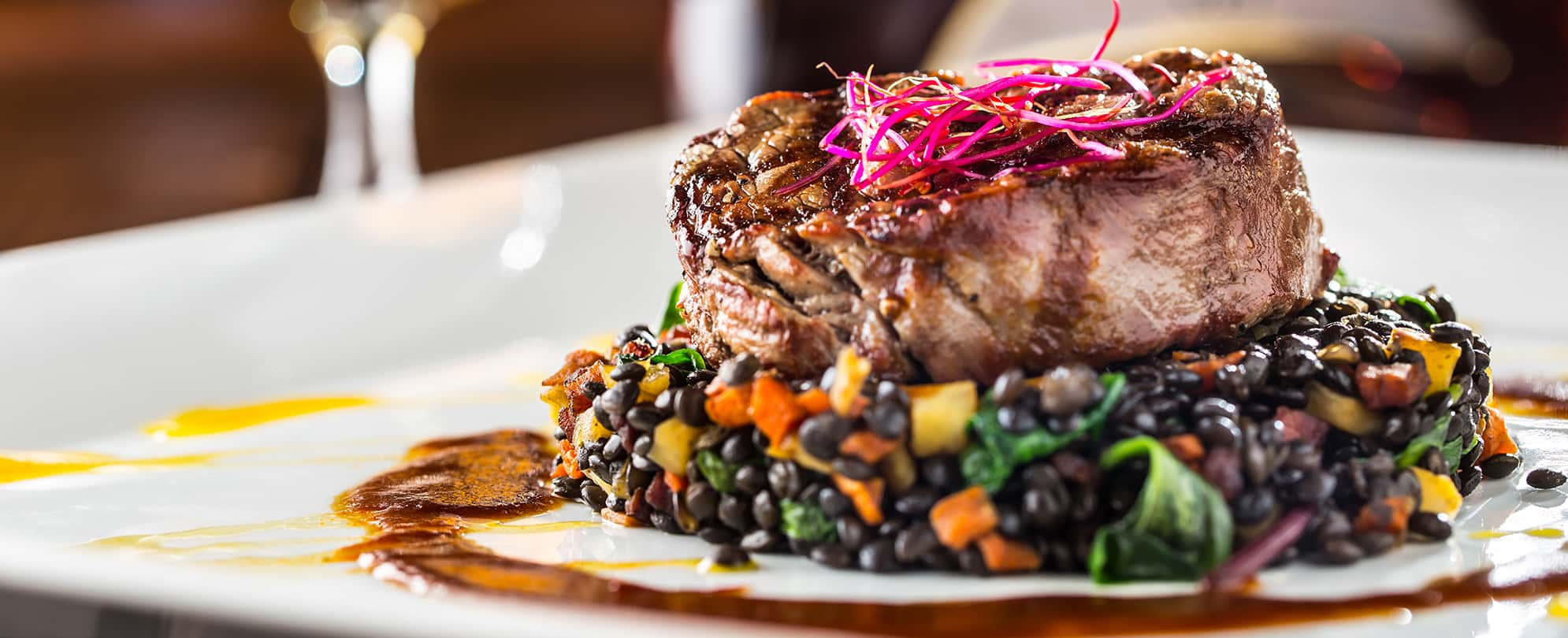 A beefsteak sitting atop black beans and vegetables at Level 2 Steakhouse in Branson, Missouri.