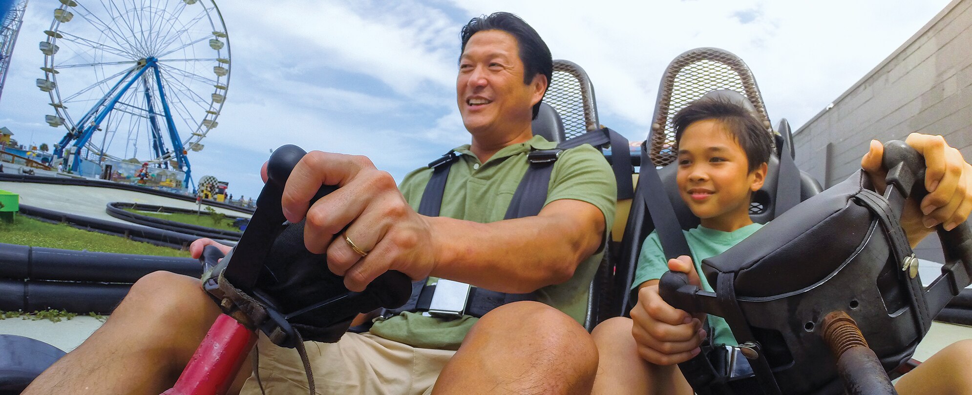 A dad and son ride in a go-kart on I-Drive in Orlando, Florida.