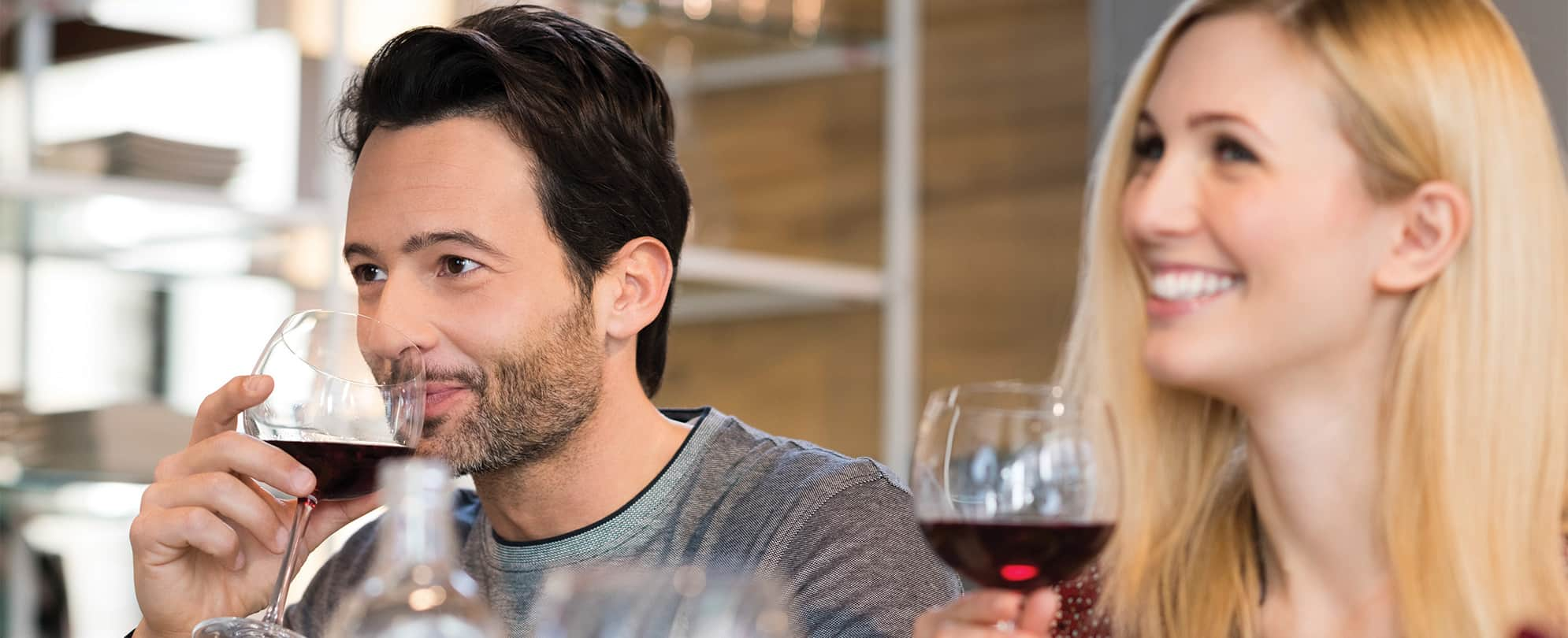 A man and woman each hold a glass of wine while wine tasting in Park City, Utah 