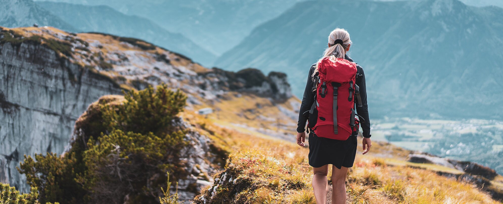 A woman backpacking on a mountain ridge during a Switzerland and Austria guided tour