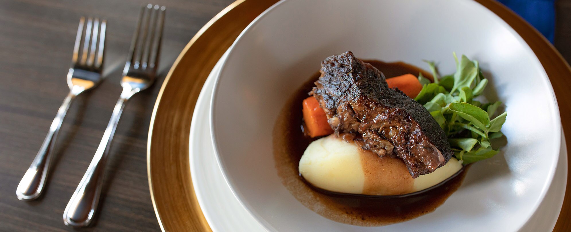 A plated dinner meal with steak, potatoes, and carrots in gravy prepared by a Club Wyndham private chef.