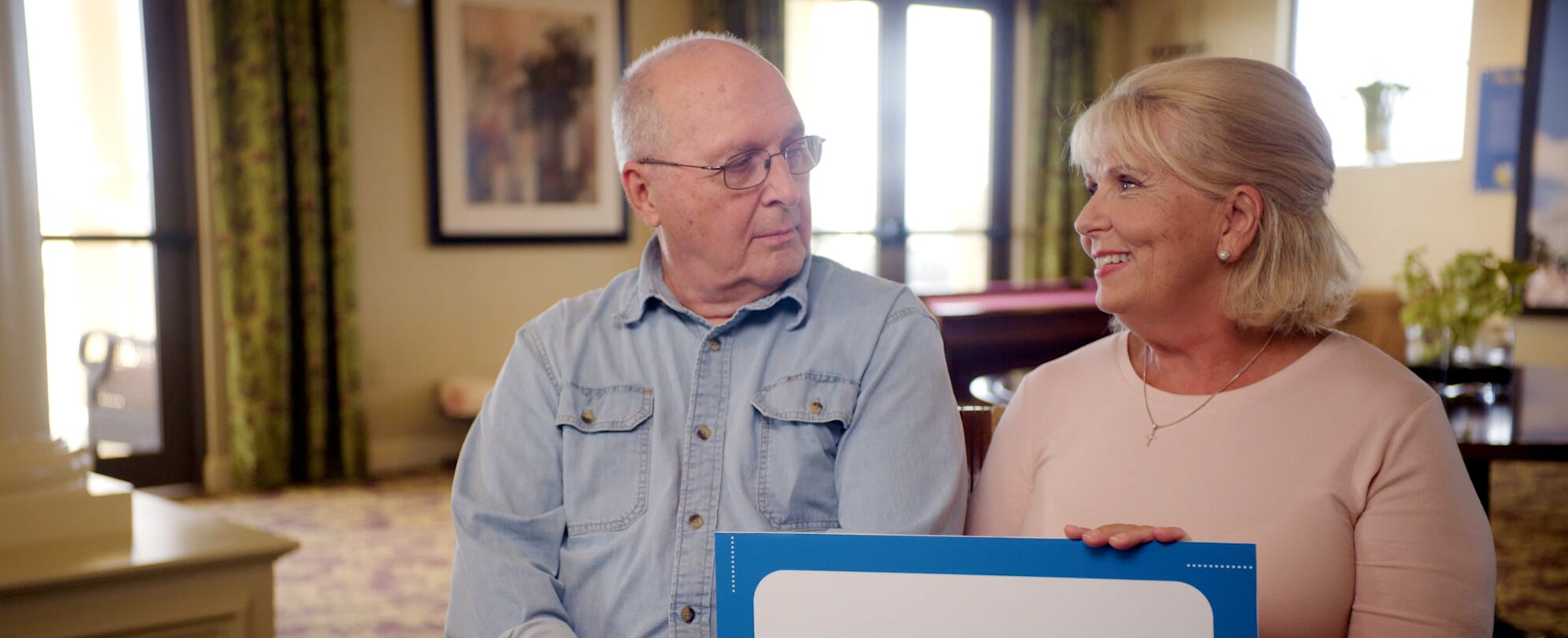 An older couple sitting next to each other answering questions about being Club Wyndham owners. 