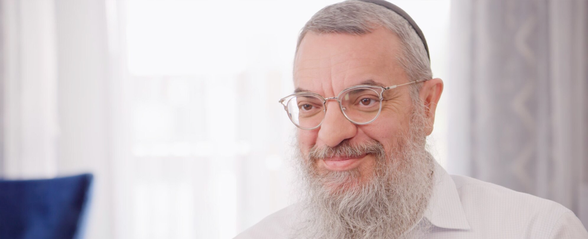 A timeshare owner wearing a kippah and candidly smiling away from the camera