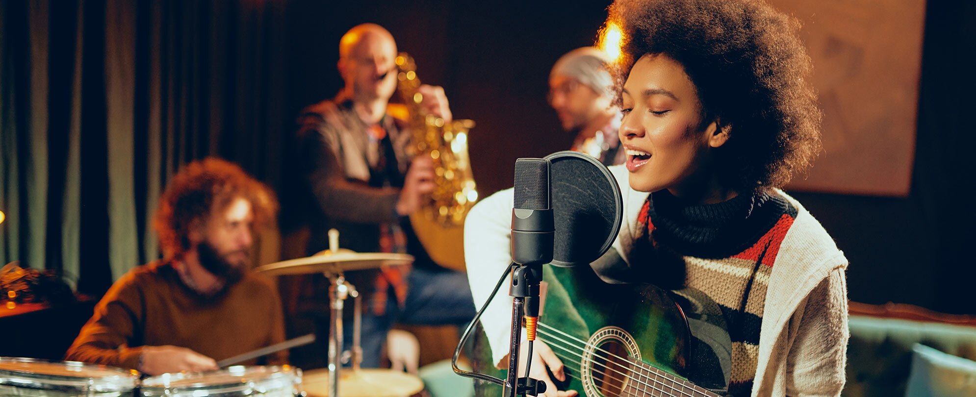 A singer playing guitar with a live band