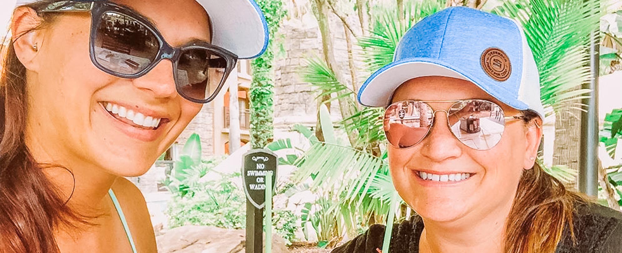 Two woman smile while holding tropical cocktails at Club Wyndham Bonnet Creek in Orlando, Florida